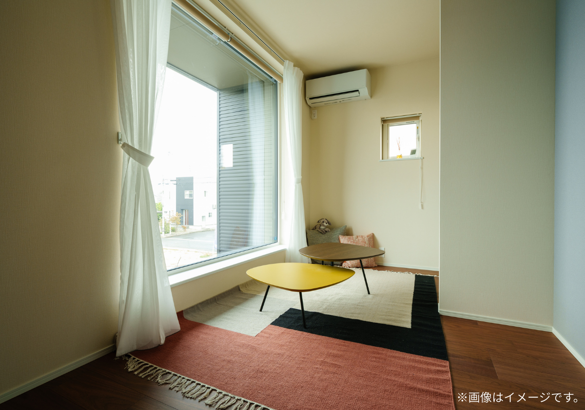 アステホームの注文住宅。大きなピクチャーウィンドウから光が差し込む明るいオープンスペース。お気に入りのラグを敷いて、読書や昼寝を楽しむ「フロアライフ」の提案事例。